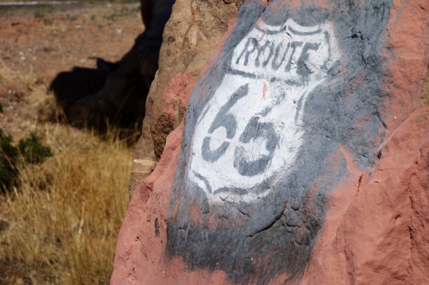 Old sign on rock along older section of Route 66